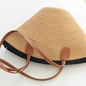 Detailed macro view of woven fiber texture with brown leather handles and metal zipper