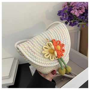 Detail of a handmade floral woven crossbody bag with colorful stitching and tassels