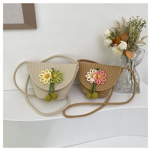 Detail of woven straw crossbody bags with sunflower accents and spherical tassels
