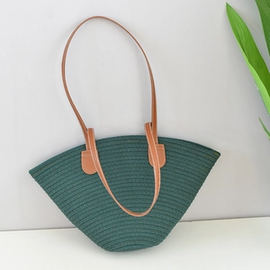 Detail of dark green woven bag with textured cotton yarn and brown stitched strap
