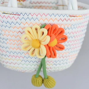 Détail du sac en coton avec coutures zigzag colorées et fleurs de soleil en tissu 3D