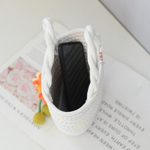 Détail intérieur du sac à main en coton avec smartphone et pendentif fleur orange décoratif