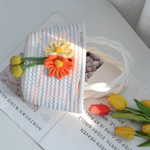 Détail d'un sac à main en coton tissé coloré avec des fleurs au crochet 3D et une anse
