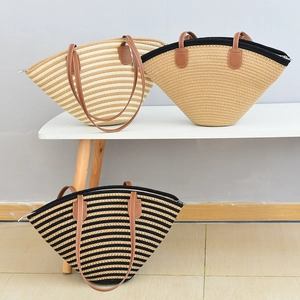 Detailed view of woven straw tote bags in three colors with leather handles and zip closure