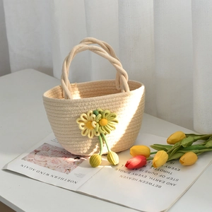 Détail du sac à main en coton tressé avec fleurs tricotées et poignées tressées robustes