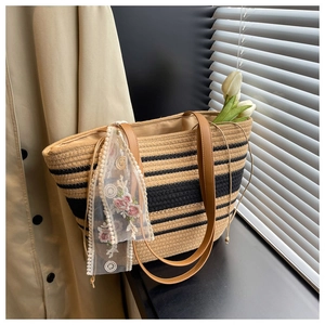 Détail du sac cabas tissé avec motif à rayures et ruban de dentelle florale