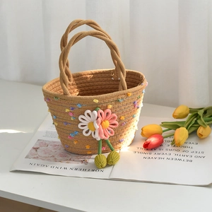 Détail d'un sac en corde de coton tissé à la main avec pompons et fleurs tricotées