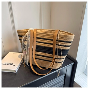 Détail d'un sac cabas tissé à rayures avec dentelle blanche et bandoulière en cuir marron