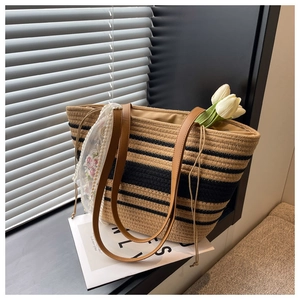 Détail du sac cabas en paille tissé main avec rayures noires et ruban en dentelle