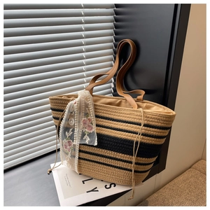 Détail du sac cabas en paille à rayures noires et ruban de dentelle à fleurs chic