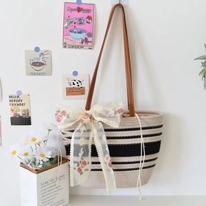 Détail du sac cabas rayé tissé main avec bandoulières en cuir et nœud en dentelle florale