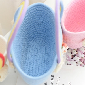 Detailed close-up of sky blue cotton rope storage basket with cute rabbit ear decor
