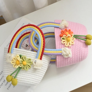 Close-up of handmade woven rope bags with rainbow straps and 3D knitted flower details