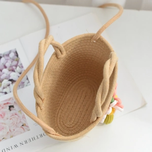 Detailed top view of beige woven straw floral bag interior with colorful 3D flower accents