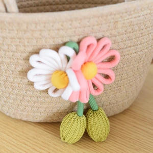 Close-up of handmade woven straw bag featuring pink and white daisy flower details