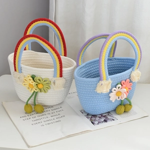 Detail of handmade woven straw bags with colorful rainbow handles and flower charms