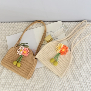 Detail view of woven cotton rope mini handbag with knitted sunflower decoration