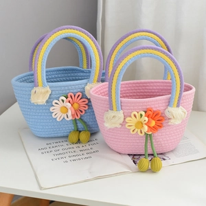 Detail of woven straw handbag featuring rainbow handles and white daisy accents