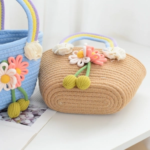 Detail of handmade woven straw handbag with rainbow handle and floral decorations