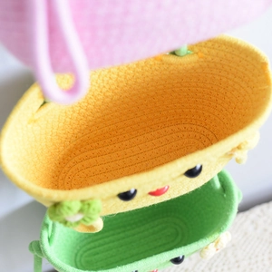 Close-up of woven cotton rope baskets with cartoon faces and cute floral details