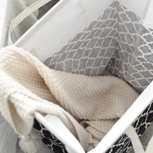 Detail view of large waterproof laundry basket with geometric patterns and fabric handles
