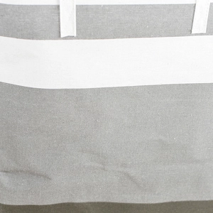 Detailed close-up of grey and white striped canvas laundry basket with durable handles