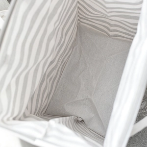 Top-down view of a large foldable laundry basket with gray striped canvas and waterproof lining