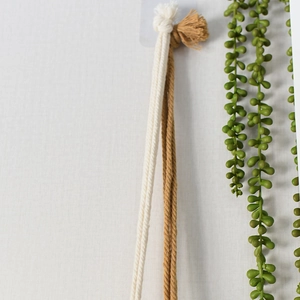 Detail of handmade woven cotton ropes in cream and camel with decorative tassel knots