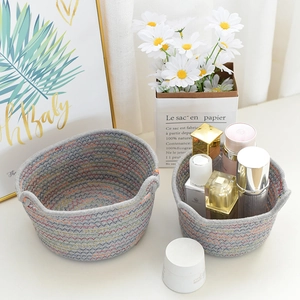 Detail of grey cotton rope storage baskets with colorful stitching and dual handles