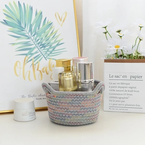 Detail of grey woven cotton rope storage basket with colorful zigzag stitching and handles