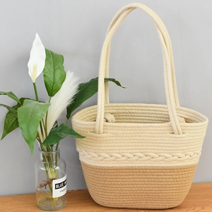 Dettaglio della borsa tote in cotone intrecciato con texture bicolore e motivi a treccia