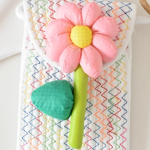 Detail der gewebten Blumentasche mit 3D-Blüte und bunten Stickmustern