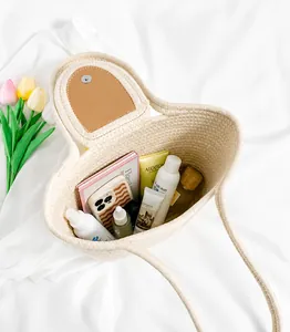 Spacious interior of woven straw tote bag with brown leather flap and magnetic closure