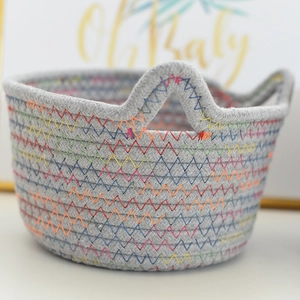 Detailed macro view of woven cotton rope basket with colorful zigzag stitching and handles