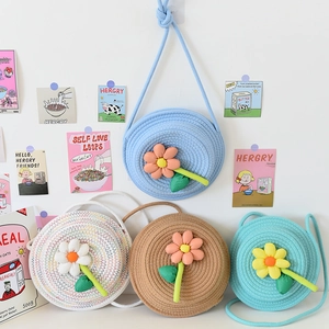 Détails de sacs à bandoulière tissés colorés avec fleurs 3D sur un mur blanc propre