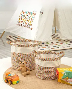 Detail of two handmade bohemian cotton rope storage baskets with dual handles and color blocking