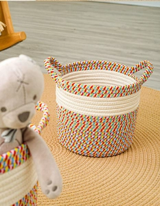 Detailed close-up of rainbow woven cotton rope storage basket with dual handles and toys