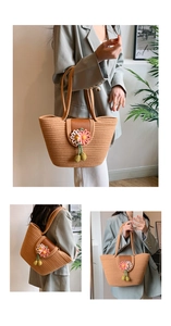 Detailed close-up of straw tote bag featuring 3D daisy flower accents and leather handles