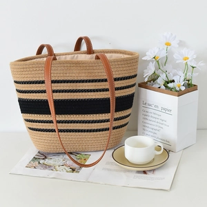 Handcrafted woven straw tote bag with black stripes and brown leather handles