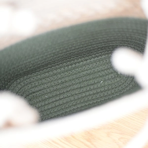 Dettaglio ravvicinato della trama intrecciata verde bosco e del materiale in cotone della borsa