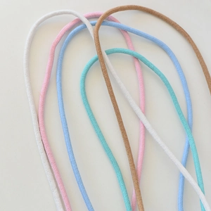 Gros plan de cordons élastiques tissés colorés en teintes pastel pour l'artisanat