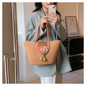 Detail of straw tote bag with 3D floral accents styled on mint green blazer