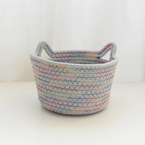 Detail of grey cotton rope storage basket featuring colorful rainbow zigzag stitching