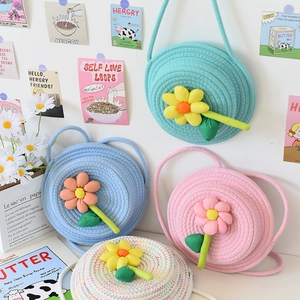 Détail de sacs bandoulière en paille tissée avec grandes fleurs en tissu pour plage d'été