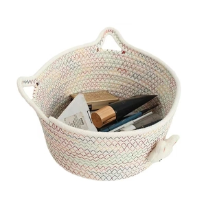 Detail of woven cotton storage basket with cat-ear handles and colorful wave stitching