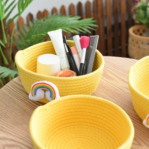 Detail of yellow cotton rope basket with rainbow applique for desktop vanity organization