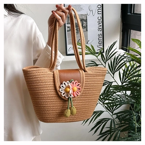 Detailed close-up of woven tote bag with leather flap and crochet flower decor
