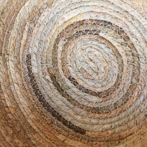 Macro detail of handwoven seagrass flower basket with spiral texture and natural brown hues