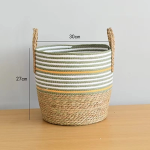 Detail of handwoven seagrass planter basket featuring green stripes and side handles