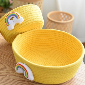 Detail of yellow woven cotton rope baskets with embroidered rainbow and cloud patches